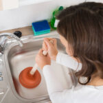woman-trying-to-Fix-clogged-drain-in-Seattle